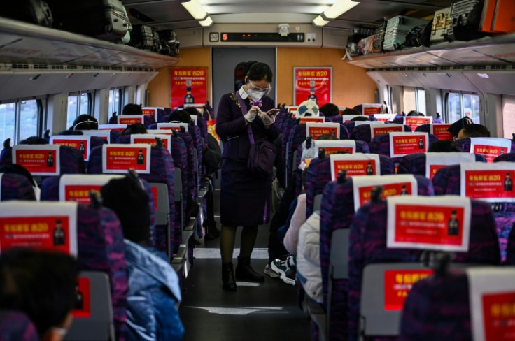 A worker checks a passenger's ticket on the train from Shanghai to Wuhan