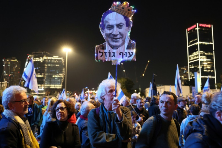 A protester holds up a caricature of Prime Minister Benjamin Netanyahu, whose return to power last month has seen a series of moves to boost the power of politicians over the courts