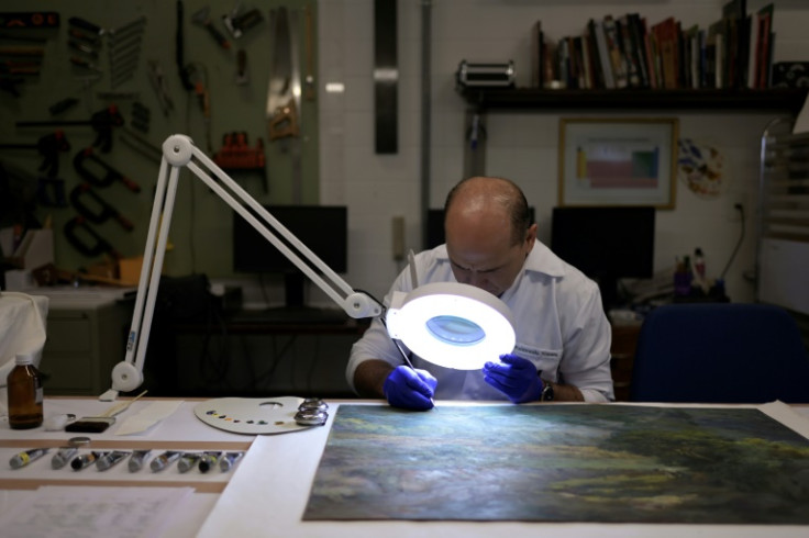 An employee works on restoring an art object damaged in the January 8 unrest in Brasilia
