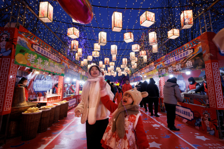 People walk through a decorated food court that is part of a Spring Festival light installation ahead of Chinese Lunar New Year in Qinglonghu Park in Beijing