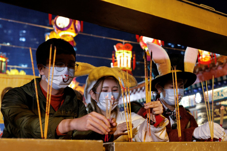Worshippers wearing face masks and rabbit ears offer of incense sticks at Lunar New Year, during the coronavirus disease (COVID-19) pandemic in Hong Kong