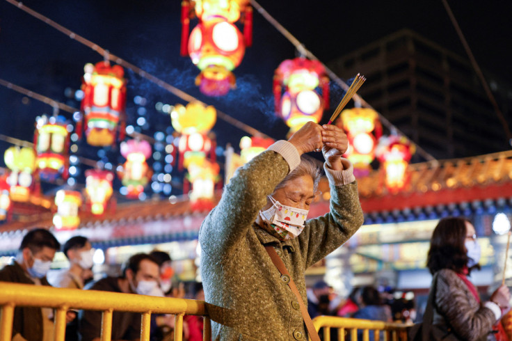 A worshipper wearing a face mask makes an offering of incense sticks ahead of Lunar New Year, during the coronavirus disease (COVID-19) pandemic in Hong Kong