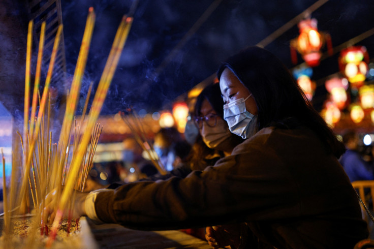 Worshippers wearing face masks make offerings of incense sticks ahead of the Lunar New Year, during the coronavirus disease (COVID-19) pandemic in Hong Kong