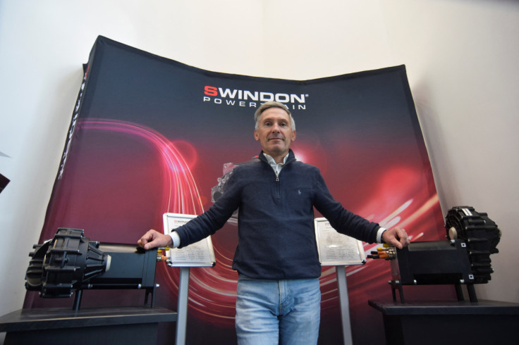 Raphael Caille, managing director of motorsport engine maker Swindon Powertrain, stands between an e-axle and electric powertrain the company has developed, in Swindon