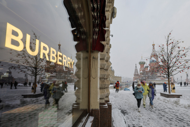 People walk past a closed Burberry boutique in the GUM department store in Red Square, during snowfall in Moscow