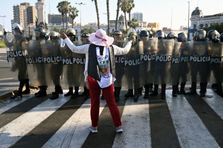 A woman confronts a riot police cordon during a protests in Lima on January 23, 2023