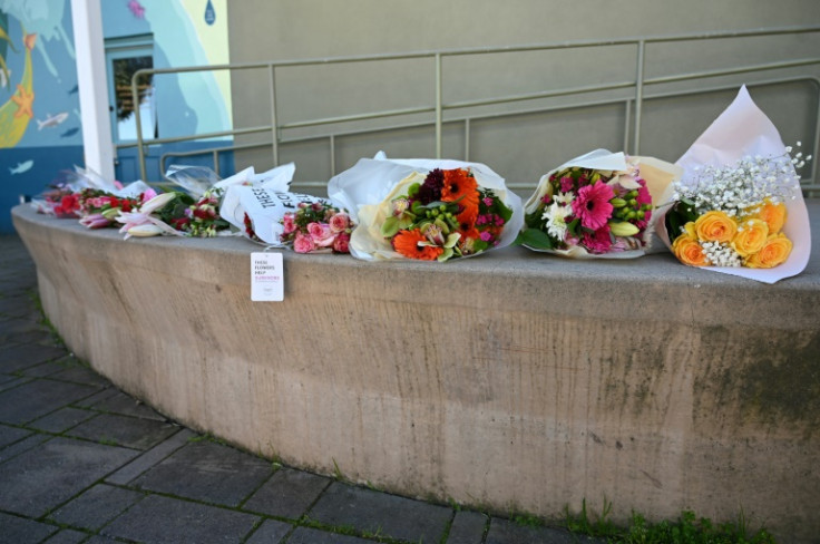 Flowers are left at an impromptu memorial to the seven victims of Monday's shooting