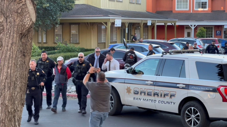 Police officers detain a man believed to be the Half Moon Bay mass shooting suspect