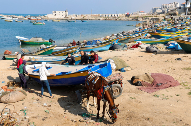 Palestinians repair a fishing boat at the seaport in Gaza City