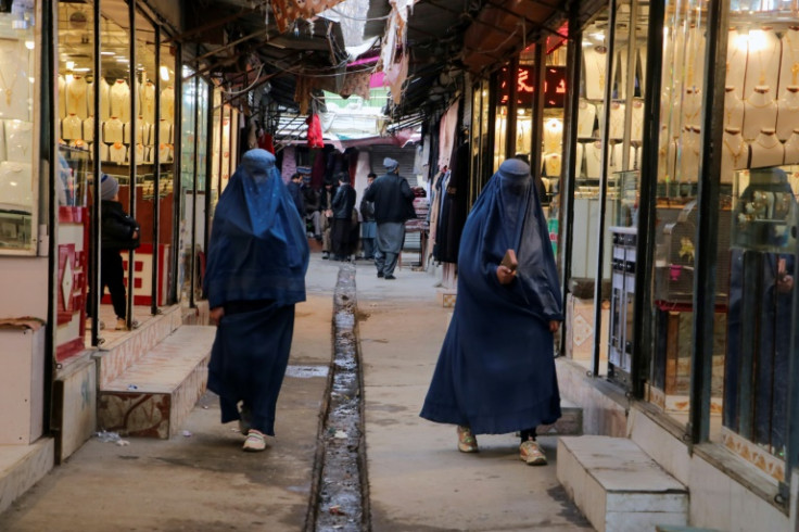 Burqa-clad women walk in a market in Afghanistan's Badakhshan province on January 23, 2023