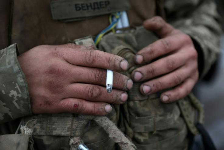 A Ukrainian soldier takes a rest on the road outside Soledar in ths January 14 file photo