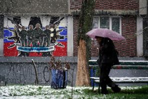 A pedestrian walks past a defaced mural to Russia's mercenary Wagner Group in Belgrade on January 20, 2023