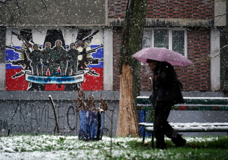 A pedestrian walks past a defaced mural to Russia's mercenary Wagner Group in Belgrade on January 20, 2023