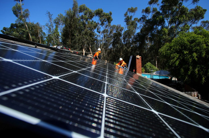 Solar installers from Baker Electric place solar panels on the roof of a residential home in Scripps Ranch, San Diego, California