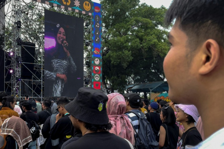 Members of the audience take in Nasida Ria's performance at a Jakarta festival on a large screen