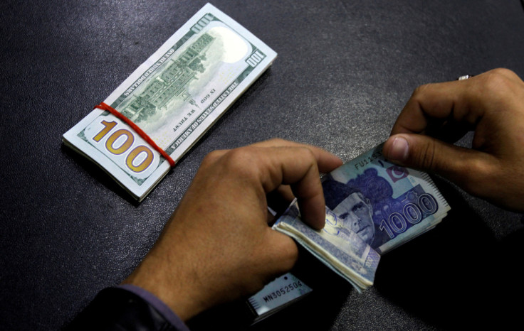 A currency trader counts Pakistani Rupee notes as he prepares an exchange of U.S dollars in Islamabad