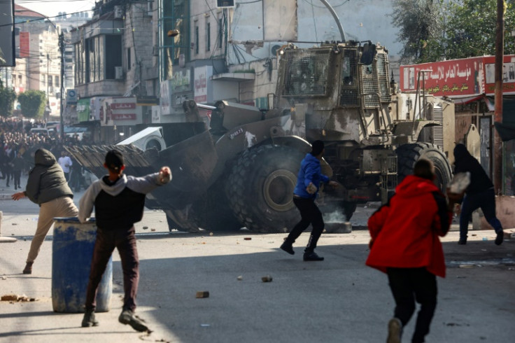 Palestinians hurl rocks at an Israeli army bulldozer during clashes on Thursday in the flashpoint West Bank city of Jenin