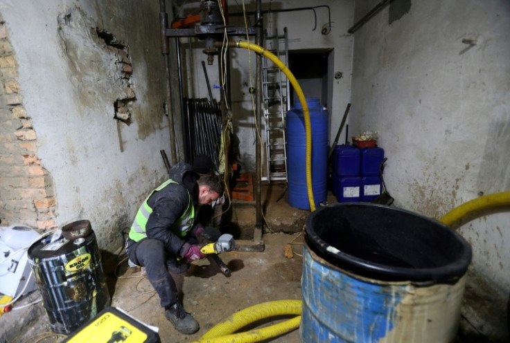 A volunteer  works to drill a well to pump water