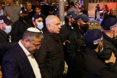 Israeli Prime Minister Benjamin Netanyahu (center) walks near Minister of National Security Itamar Ben-Gvir (left) at the site of an attack outside a synagogue in a settler neighborhood of Israeli-annexed east Jerusalem