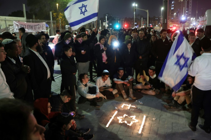 Israeli youths hold a candlelight vigil at the site of Friday's attack in annexed east Jerusalem