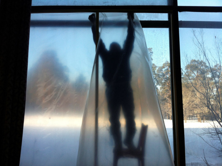 A man repairs the window of a sports hall damaged by a shockwave from a meteor in the Urals city of Chelyabinsk