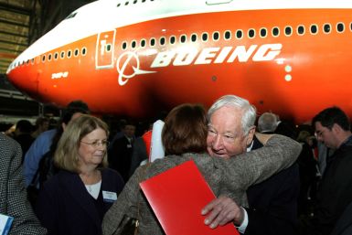 Joe Sutter, Boeing's chief engineer on the original jumbo, hugs a woman in front of a newly unveiled 747-8 jumbo passenger jet in Everett