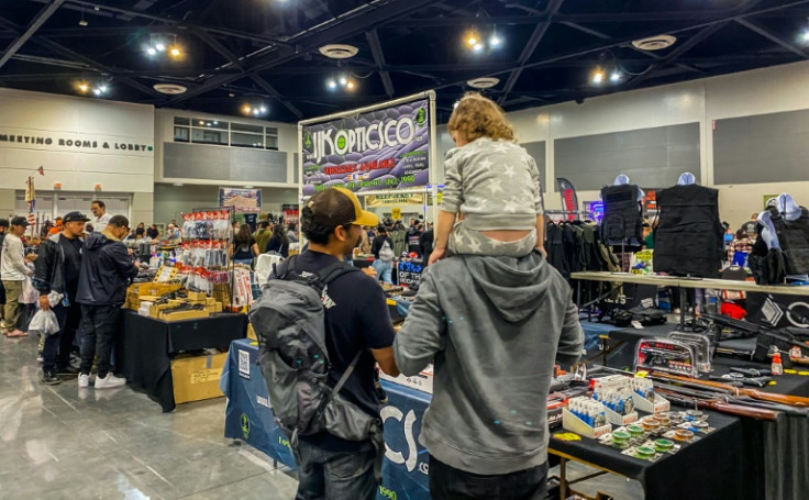 Familes browse at the Crossroads of the West Gun Show at the Convention Center in Ontario, California, on January 28, 2023