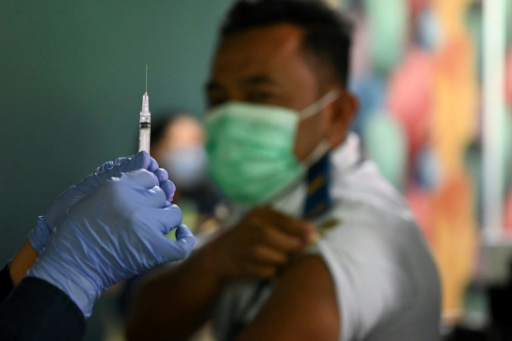 A health worker prepares a Covid booster jab for an airport worker in Bali