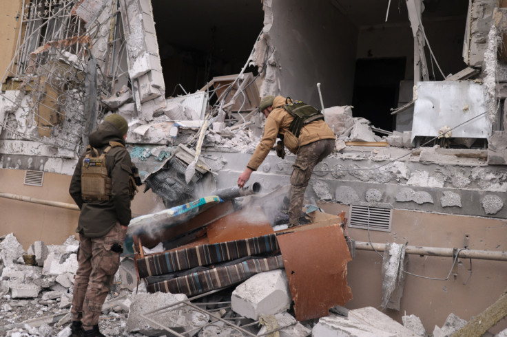 Ukrainian service men remove a grad rocket in a damaged house, in Kherson