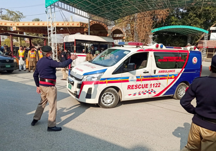 A police officer guides an ambulance after a suicide blast in a mosque, at police line area in Peshawar