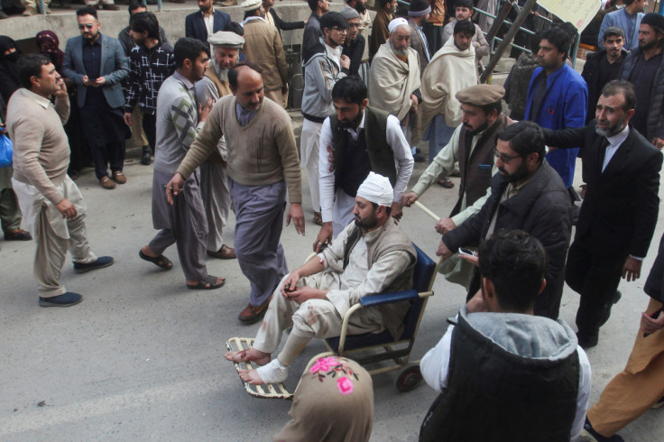 Men move an injured victim, after a suicide blast in a mosque, at hospital premises in Peshawar