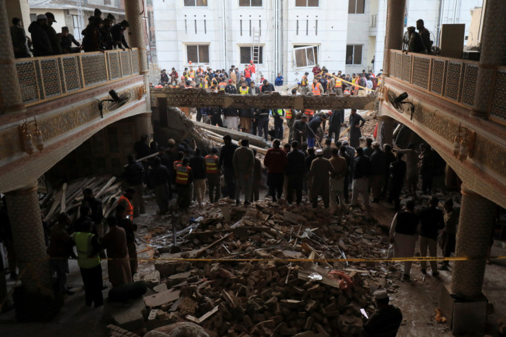 Rescue workers look for survivors after a suicide blast in a mosque in Peshawar