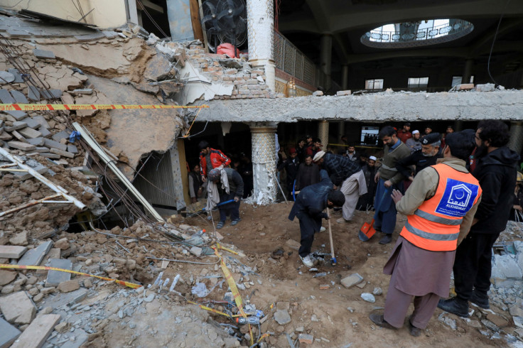 People and rescue workers remove the rubble, after a suicide blast in a mosque in Peshawar