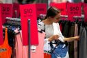 FILE PHOTO - A shopper holds items and looks at others on sale at a clothing retail store in central Sydney, Australia