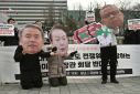 Anti-war activists in Seoul hold images of South Korean President Yoon Suk-yeol (C), Defense Minister Lee Jong-sup (L) and US Secretary of Defense Lloyd Austin