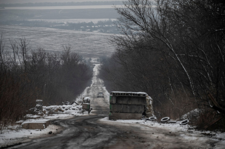 Car rides on an empty road near a frontline in Donetsk region