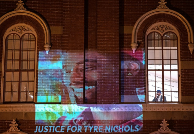A security guard looks out of a window as protesters project an image of Tyre Nichols during rally against his killing, in Washington, DC, on January 27, 2023