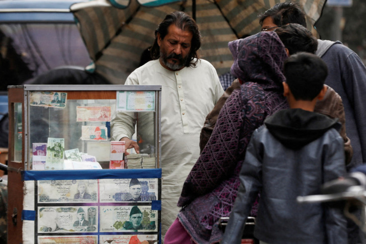 A currency broker with customers, along a road in Karachi