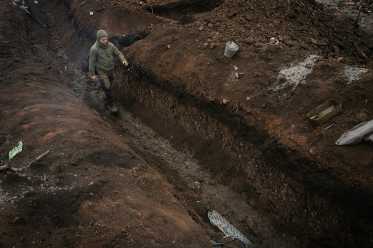 A Ukrainian serviceman walks in a trench near a frontline position in the Donetsk region