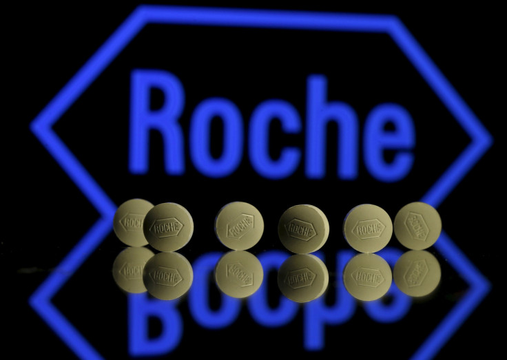 Roche tablets are seen positioned in front of a displayed Roche logo in this photo illustration