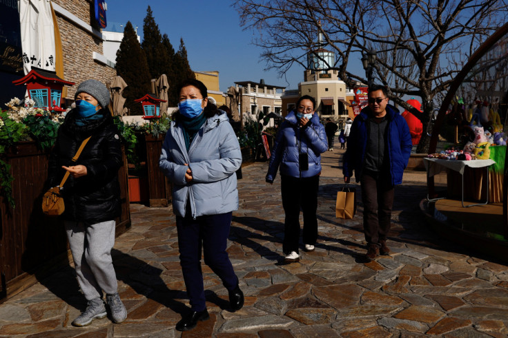 People walk past restaurant in a shopping area in Beijing