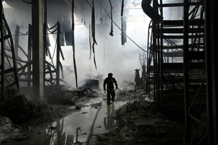 A Ukrainian firefighter walks amid rubbles in a shopping mall following a Russian shelling in Kherson