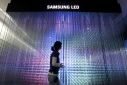 An employee of Samsung Electronics walks past LED lighting drums displayed for visitors at a showroom in Seoul