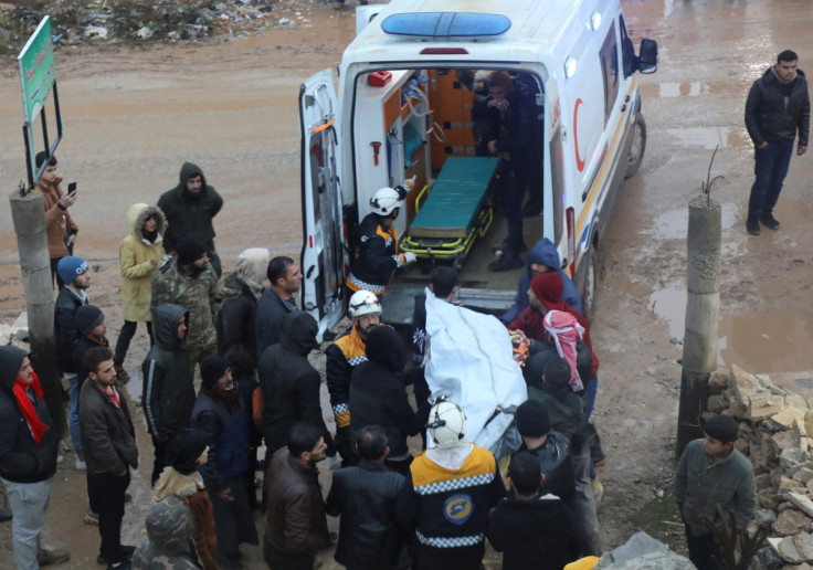 Rescuers carry a casualty at the site of a damaged building, following an earthquake, in rebel-held Azaz,