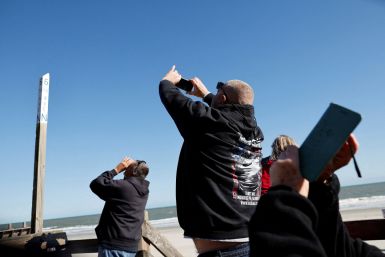 People photograph a suspected Chinese spy balloon as it floats off the coast in Surfside Beach