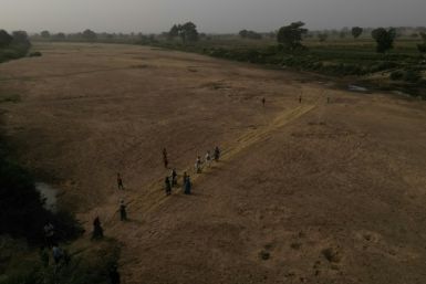 Residents cross the dry river bed that separates Ghana from Burkina and work on farms on the other side of the frontier