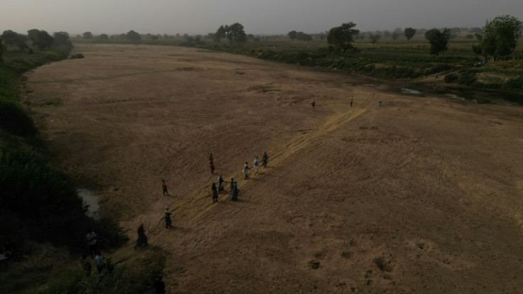 Residents cross the dry river bed that separates Ghana from Burkina and work on farms on the other side of the frontier