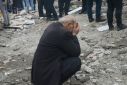 A man puts his head in his hands as people search for survivors in Diyarbakir, southeast Turkey