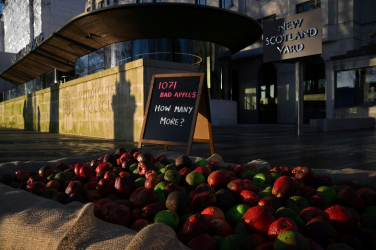 Mock rotten apples outside Scotland Yard in protest over officers being investigated for violence against women