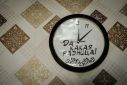A clock whose hands move anti-clockwise with a message in Russian meaning "what's the difference!" hangs in the home of Victoria Shypko in Yampil, eastern Ukraine